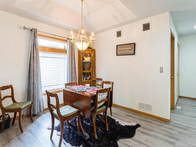 5213 SE 30th St, Des Moines, IA 50320 - dining area featuring a chandelier, light wood-style floors, and baseboards