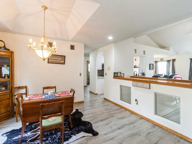 5213 SE 30th St, Des Moines, IA 50320 - dining room featuring light wood-style floors, a chandelier, arched walkways, lofted ceiling, and baseboards