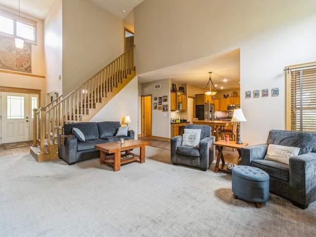 6818 Jules Verne Ct, Johnston, IA 50131 - living room with a high ceiling, stairs, and light carpet