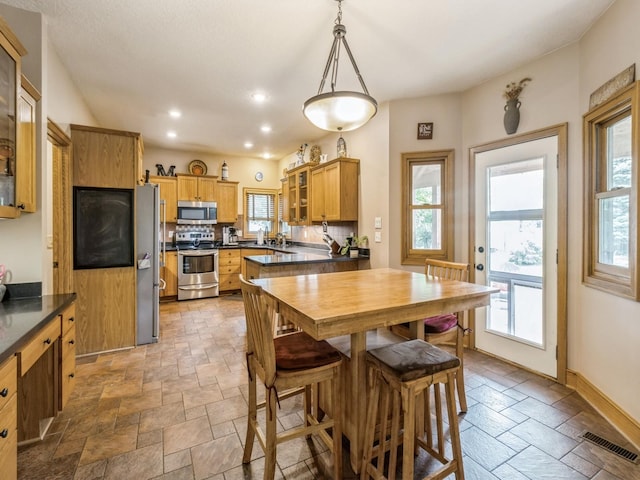 6818 Jules Verne Ct, Johnston, IA 50131 - dining room with healthy amount of natural light, stone tile flooring, recessed lighting, and baseboards
