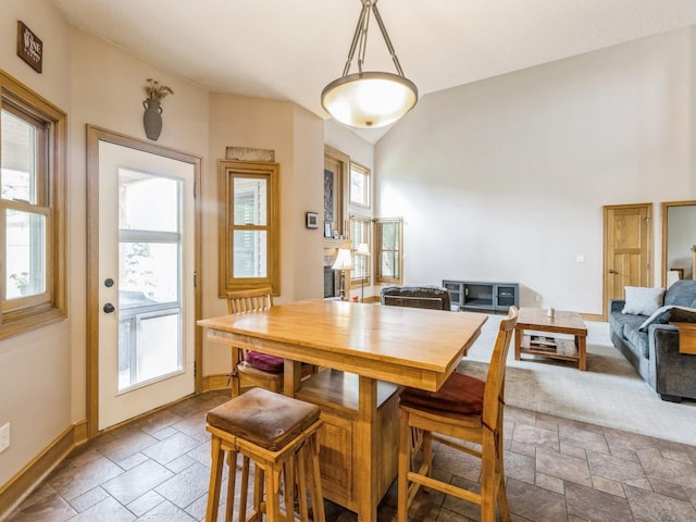6818 Jules Verne Ct, Johnston, IA 50131 - dining room with stone tile floors, healthy amount of natural light, baseboards, and vaulted ceiling