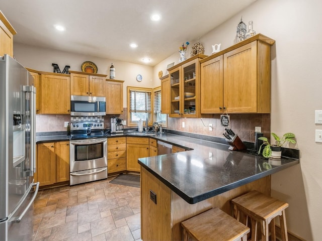 6818 Jules Verne Ct, Johnston, IA 50131 - kitchen featuring stainless steel appliances, a peninsula, decorative backsplash, glass insert cabinets, and recessed lighting