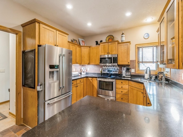 6818 Jules Verne Ct, Johnston, IA 50131 - kitchen featuring appliances with stainless steel finishes, a sink, backsplash, recessed lighting, and dark stone counters