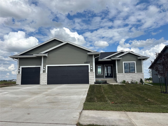 4657 177th St, Urbandale, IA 50322 - craftsman inspired home featuring stone siding, a front lawn, an attached garage, and driveway