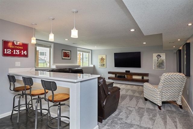 1880 Brodie St, Waukee, IA 50263 - kitchen featuring baseboards, recessed lighting, a breakfast bar, light countertops, and a textured ceiling