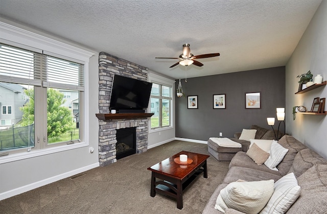 1880 Brodie St, Waukee, IA 50263 - living area featuring a ceiling fan, a stone fireplace, carpet floors, a textured ceiling, and baseboards