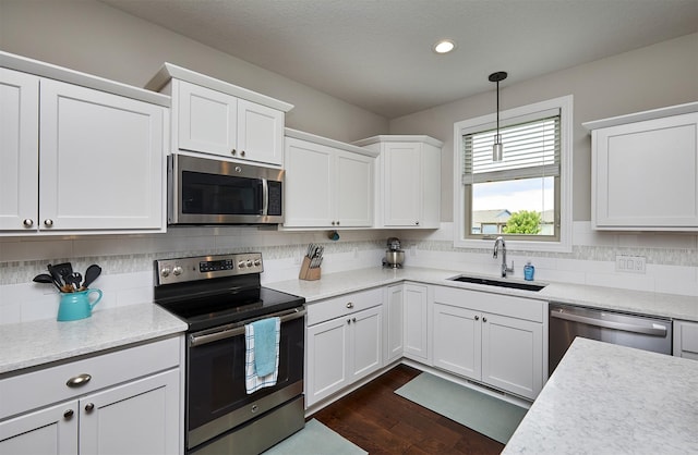 1880 Brodie St, Waukee, IA 50263 - kitchen with stainless steel appliances, a sink, white cabinets, tasteful backsplash, and recessed lighting