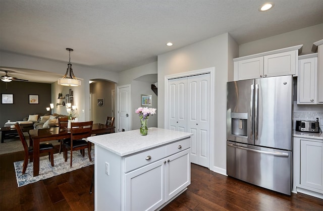 1880 Brodie St, Waukee, IA 50263 - kitchen with stainless steel fridge with ice dispenser, arched walkways, dark wood finished floors, recessed lighting, and hanging light fixtures