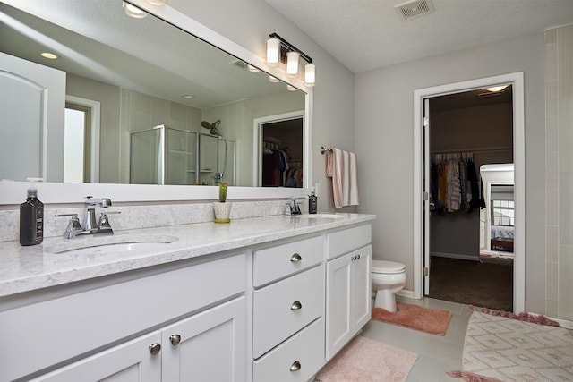 1880 Brodie St, Waukee, IA 50263 - bathroom featuring a spacious closet, double vanity, a stall shower, toilet, and tile patterned floors