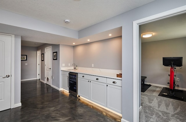 1880 Brodie St, Waukee, IA 50263 - kitchen with beverage cooler, a sink, baseboards, recessed lighting, and a textured ceiling