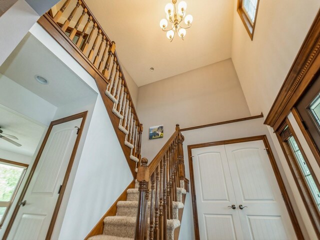 8305 Century Dr, West Des Moines, IA 50266 - stairway featuring a high ceiling and a chandelier