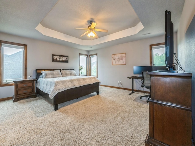 8305 Century Dr, West Des Moines, IA 50266 - bedroom featuring a tray ceiling, light carpet, multiple windows, and a desk