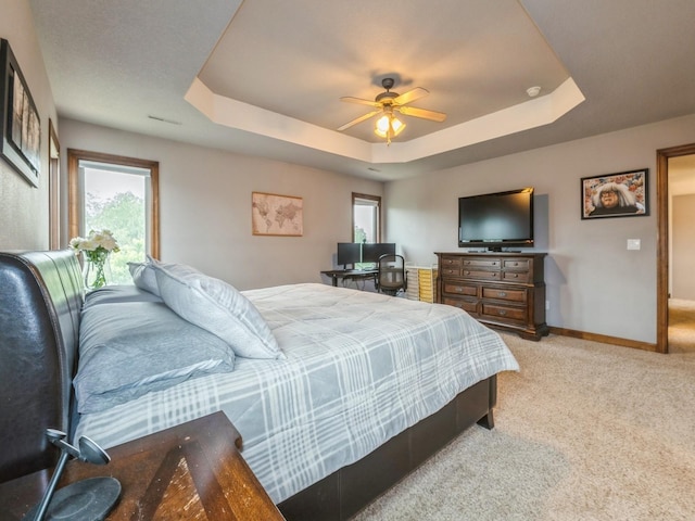 8305 Century Dr, West Des Moines, IA 50266 - bedroom with light carpet, a tray ceiling, and ceiling fan