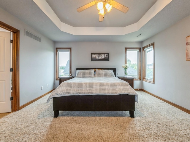 8305 Century Dr, West Des Moines, IA 50266 - carpeted bedroom with a tray ceiling and a ceiling fan