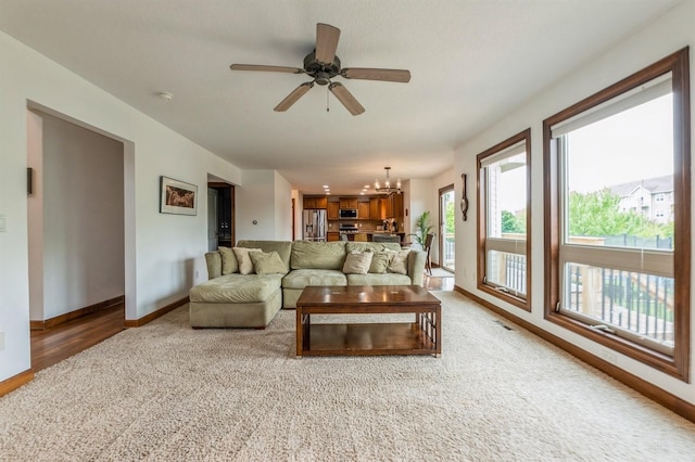 8305 Century Dr, West Des Moines, IA 50266 - living room with a chandelier, light colored carpet, ceiling fan, and light wood-style floors