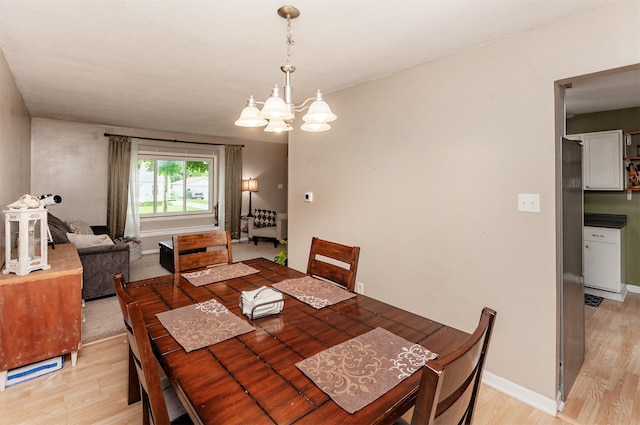 4006 67th St, Urbandale, IA 50322 - dining area with light wood-style floors, a chandelier, and baseboards