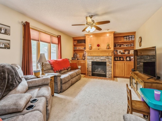 1506 W 17th St S, Newton, IA 50208 - living room featuring a stone fireplace, ceiling fan, light carpet, and a textured ceiling