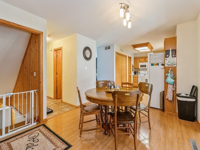 1506 W 17th St S, Newton, IA 50208 - dining area featuring light wood finished floors and a textured ceiling