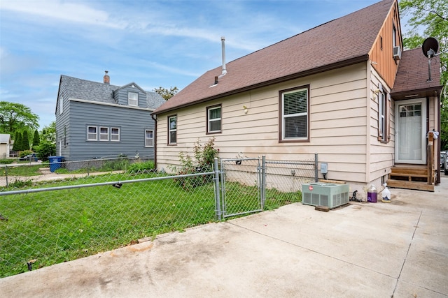 1452 55th St, Des Moines, IA 50311 - view of property exterior featuring a patio, entry steps, central AC, a gate, and a shingled roof