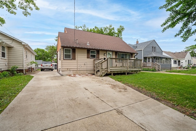 1452 55th St, Des Moines, IA 50311 - bungalow-style home featuring a front yard, driveway, and a wooden deck