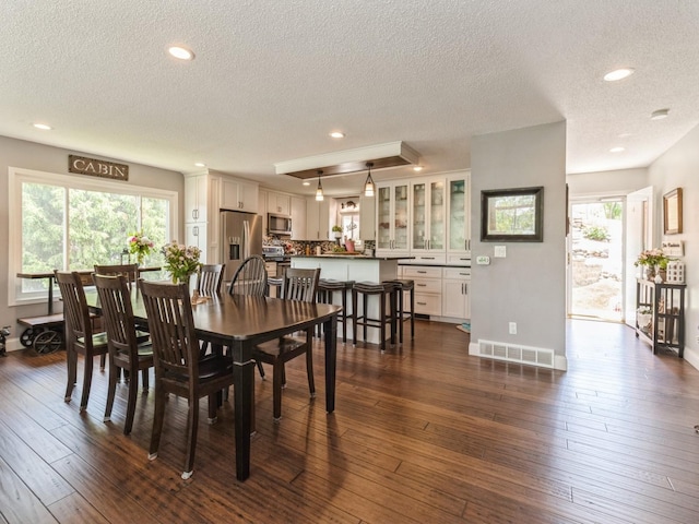 201 Cottage Ln, Montezuma, IA 50171 - dining space featuring a textured ceiling, baseboards, dark wood-type flooring, healthy amount of natural light, and recessed lighting