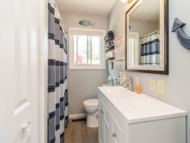201 Cottage Ln, Montezuma, IA 50171 - full bathroom with vanity, wood finished floors, toilet, and baseboards