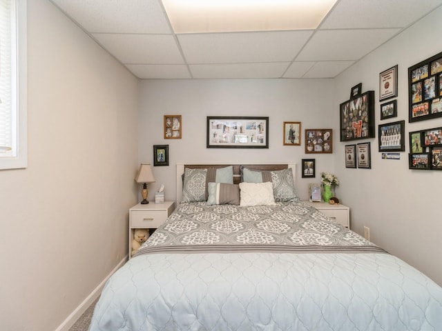 201 Cottage Ln, Montezuma, IA 50171 - bedroom featuring a drop ceiling, carpet floors, and baseboards
