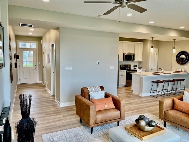 5428 153rd St, Urbandale, IA 50323 - living area featuring light wood-style floors, a ceiling fan, baseboards, and recessed lighting