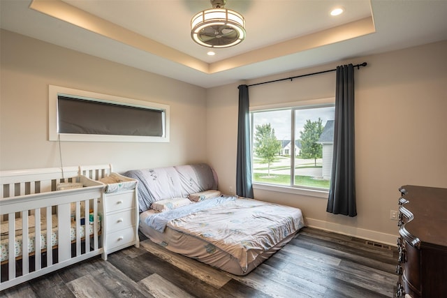 3021 NE 17th St, Ankeny, IA 50021 - bedroom with dark wood-style floors, a tray ceiling, recessed lighting, and baseboards