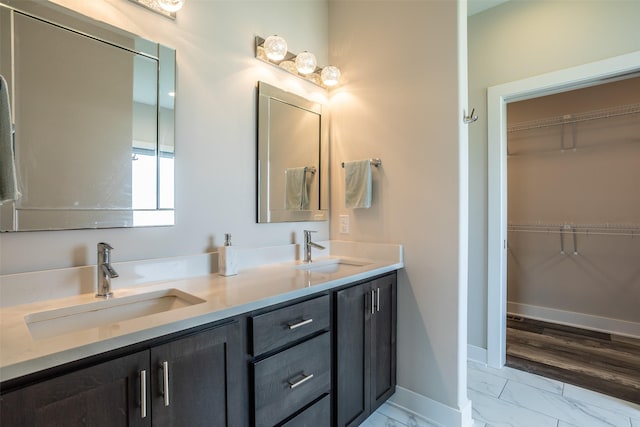 3021 NE 17th St, Ankeny, IA 50021 - full bathroom featuring marble finish flooring, double vanity, baseboards, and a walk in closet