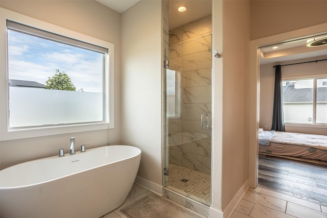 3021 NE 17th St, Ankeny, IA 50021 - ensuite bathroom with baseboards, marble finish flooring, a soaking tub, a marble finish shower, and recessed lighting