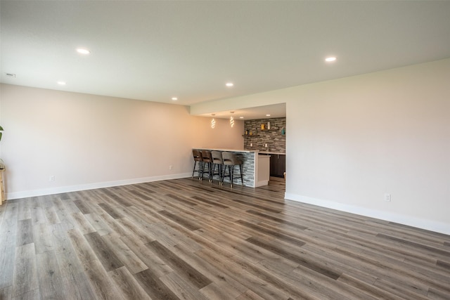 3021 NE 17th St, Ankeny, IA 50021 - unfurnished living room featuring bar with sink, wood finished floors, recessed lighting, and baseboards