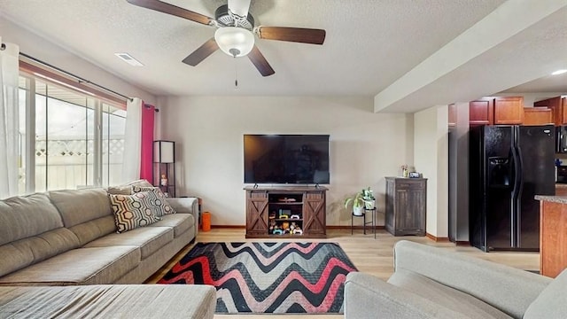 1401 N 6th St Unit 7, Indianola, IA 50125 - living room featuring a ceiling fan, light wood-style flooring, a textured ceiling, and baseboards
