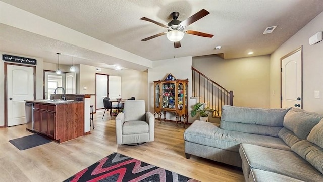 1401 N 6th St Unit 7, Indianola, IA 50125 - living area with stairway, ceiling fan, light wood-type flooring, and a textured ceiling