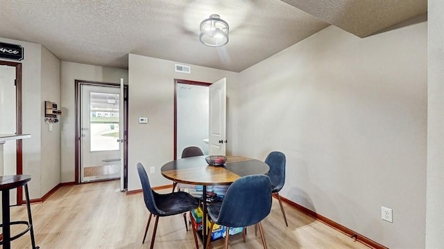 1401 N 6th St Unit 7, Indianola, IA 50125 - dining room with light wood-style flooring, a textured ceiling, and baseboards