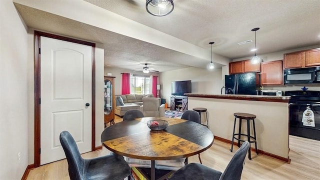 1401 N 6th St Unit 7, Indianola, IA 50125 - dining room featuring light wood-style floors, baseboards, ceiling fan, and a textured ceiling