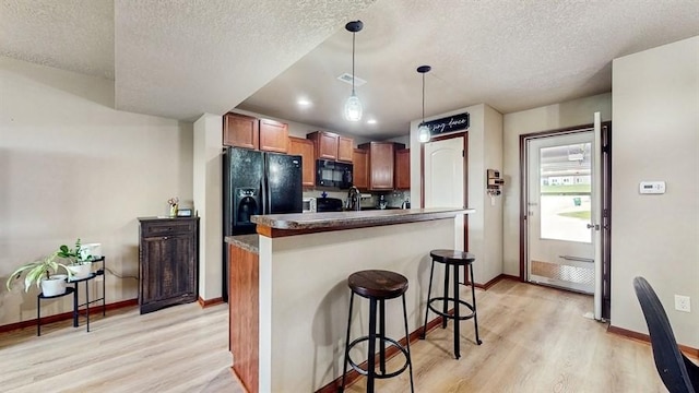 1401 N 6th St Unit 7, Indianola, IA 50125 - kitchen with black appliances, a textured ceiling, light wood-style flooring, baseboards, and pendant lighting