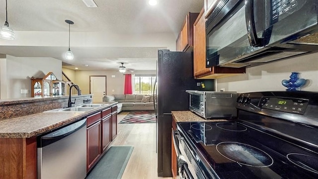 1401 N 6th St Unit 7, Indianola, IA 50125 - kitchen featuring black appliances, a sink, light wood-style floors, open floor plan, and decorative light fixtures