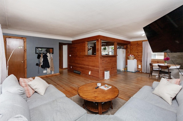 3020 62nd St, Des Moines, IA 50322 - living area featuring wood finished floors, water heater, ornamental molding, and wood walls