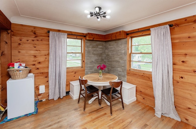 3020 62nd St, Des Moines, IA 50322 - dining space with light wood-style floors, wooden walls, and a chandelier