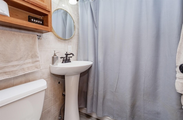 3020 62nd St, Des Moines, IA 50322 - full bath featuring toilet, tile walls, a shower with shower curtain, backsplash, and a sink