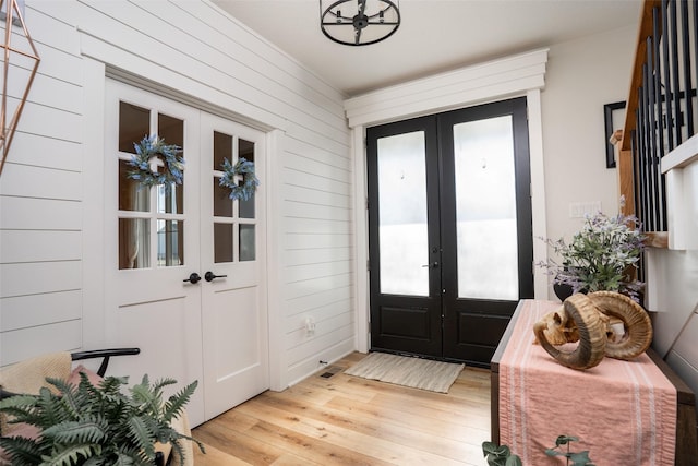 3338 9th Ave SW, Altoona, IA 50009 - foyer with french doors, light wood finished floors, and wooden walls