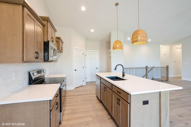 3412 5th Ave SE, Altoona, IA 50009 - kitchen featuring appliances with stainless steel finishes, a sink, light wood-type flooring, tasteful backsplash, and an island with sink