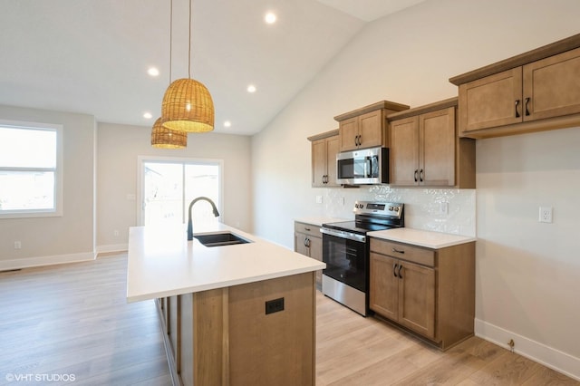 3412 5th Ave SE, Altoona, IA 50009 - kitchen with appliances with stainless steel finishes, a sink, a center island with sink, light wood-type flooring, and backsplash