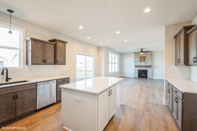 3418 5th Ave SE, Altoona, IA 50009 - kitchen featuring stainless steel dishwasher, a sink, a ceiling fan, light countertops, and light wood finished floors