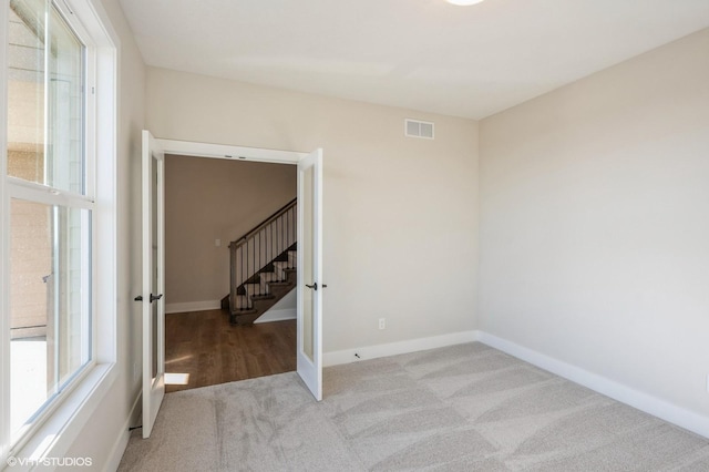 3418 5th Ave SE, Altoona, IA 50009 - spare room with carpet, baseboards, and stairs