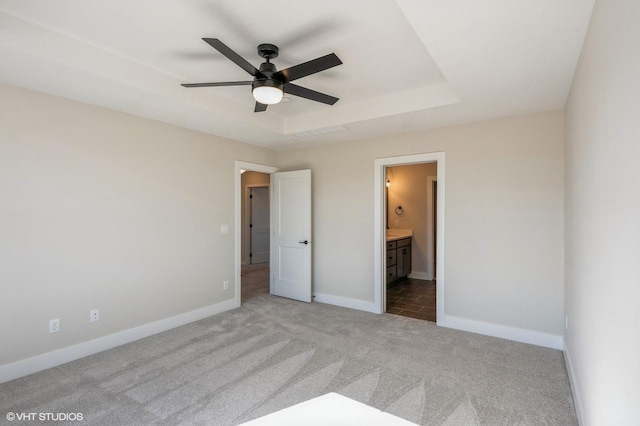 3418 5th Ave SE, Altoona, IA 50009 - unfurnished bedroom with carpet floors, baseboards, connected bathroom, and a raised ceiling
