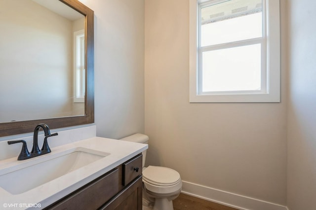 3418 5th Ave SE, Altoona, IA 50009 - half bathroom featuring toilet, vanity, and baseboards