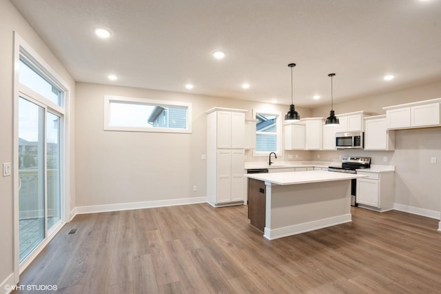 3424 5th Ave SE, Altoona, IA 50009 - kitchen with appliances with stainless steel finishes, a sink, wood finished floors, white cabinetry, and recessed lighting