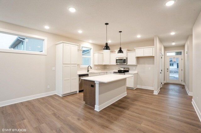 3424 5th Ave SE, Altoona, IA 50009 - kitchen with appliances with stainless steel finishes, a sink, a kitchen island, white cabinetry, and recessed lighting